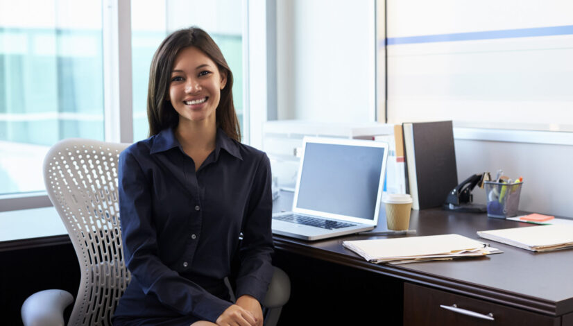Portrait Of Female Medical Professional Sitting At Desk In Office