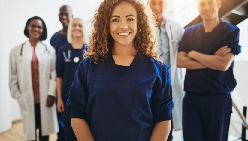 Smiling female medical professional standing with medical colleagues in a hospital